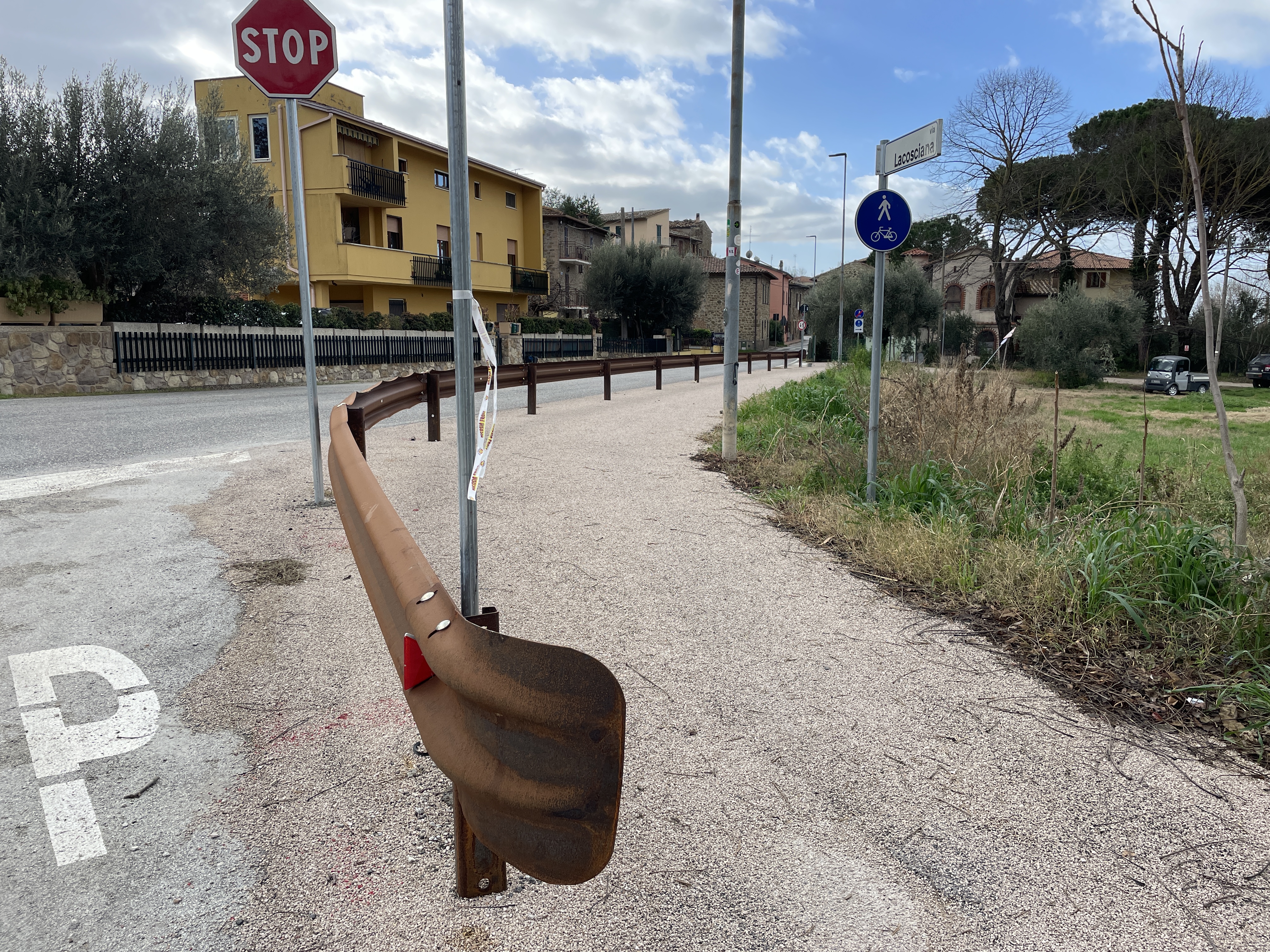 Eingang des Radwegs in Torricella. Links die Straße mit Stoppschild. Auf der rechten Seite der Radweg. Die beiden durch Leitplanken getrennt